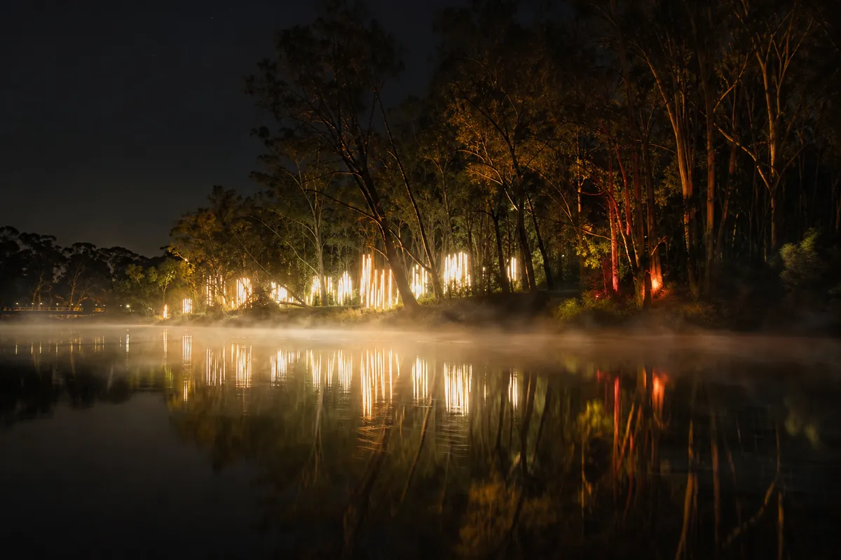 Illustration of luminous reflections and gentle mist across a river at night.